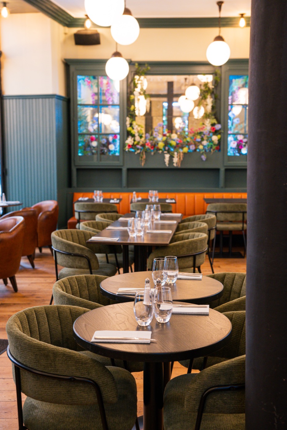 Tables rondes et suspensions en verre opalin au Bistrot Jad